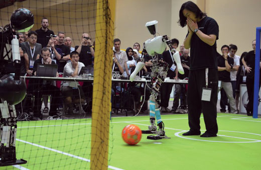 Doctoral student Jeakweon Han anxiously stands by as CHARLI 2 kicks a ball.