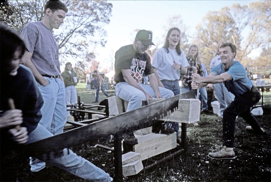 Virginia Tech students holding a log-cutting contest