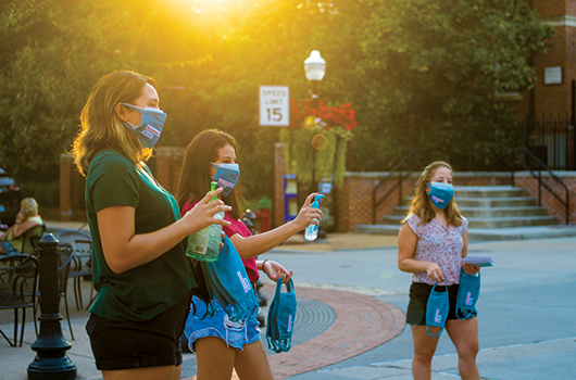 students hand out masks