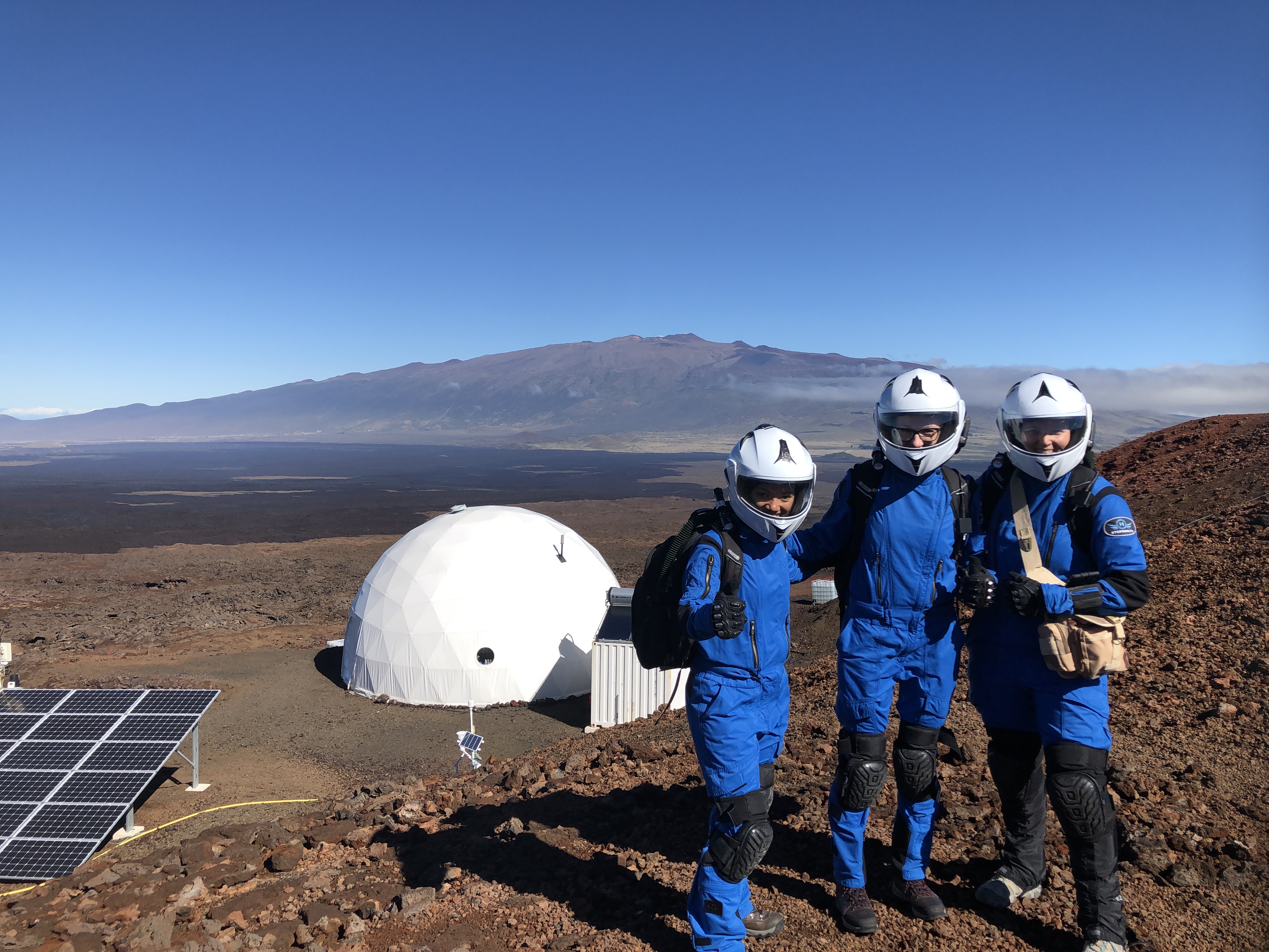 three people standing outside the Hawaii Space Exploration Analog and Simulation (HI-SEAS) habitat