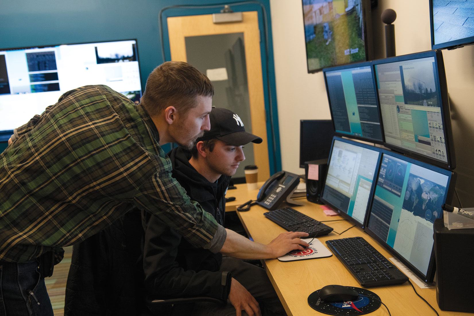 two men looking at monitor screens