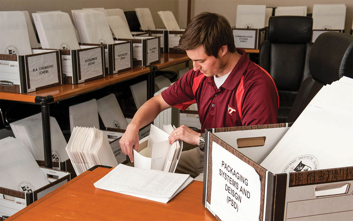 Registrar's office employeed sorting diplomas