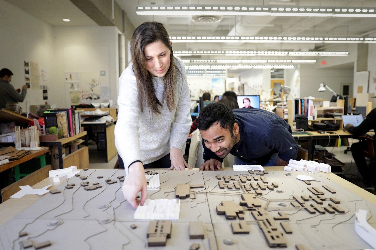 Virginia Tech architecture students Lindsey Blum (left) and Dhawal Jain work with a site model of Mzuzu University's campus.