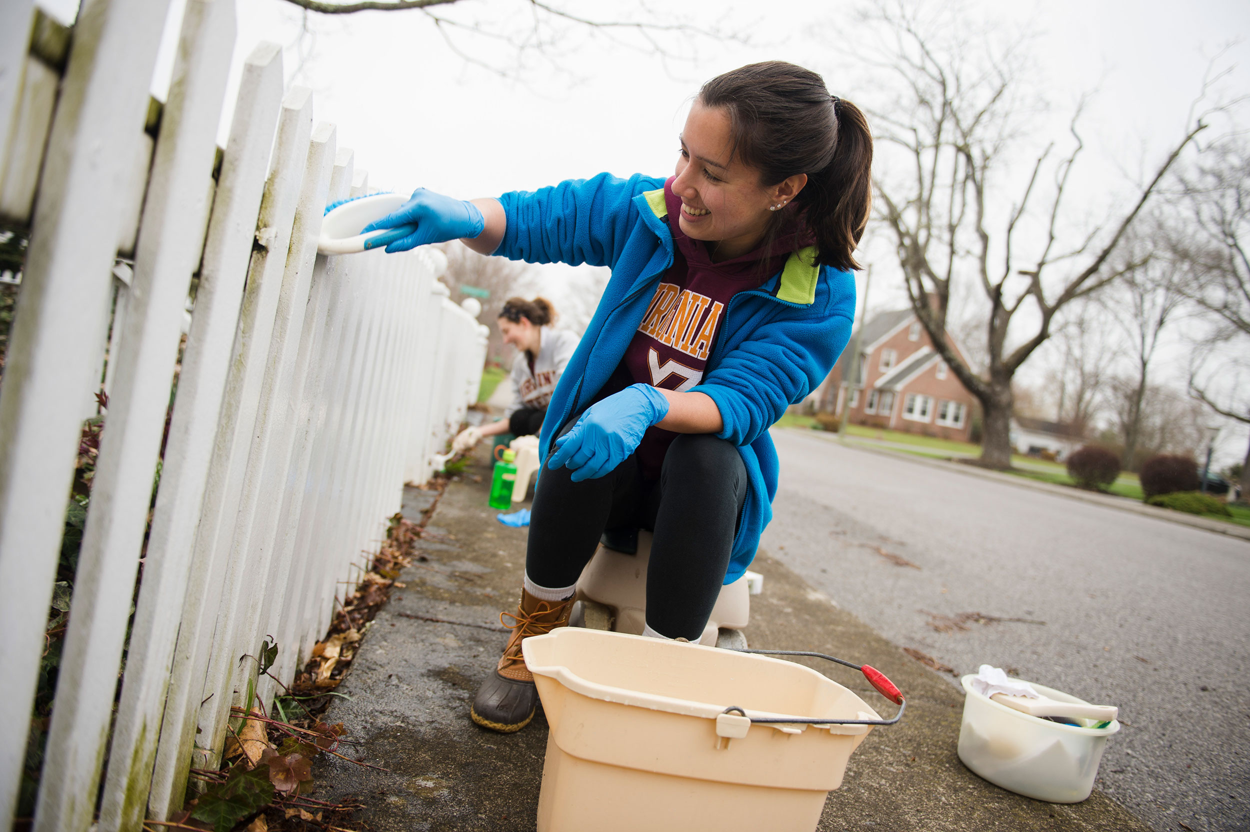 student cleaning fence