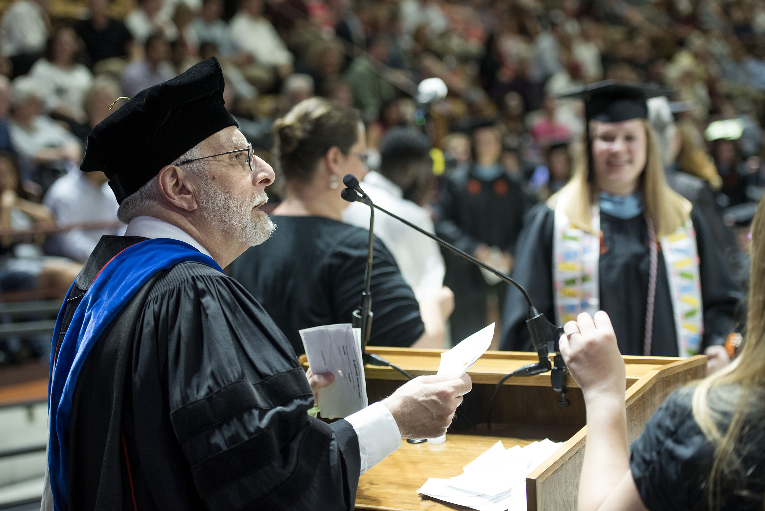 Joe Merola reads the names of graduates during the Graduate School Commencement Ceremony in Cassell Coliseum.