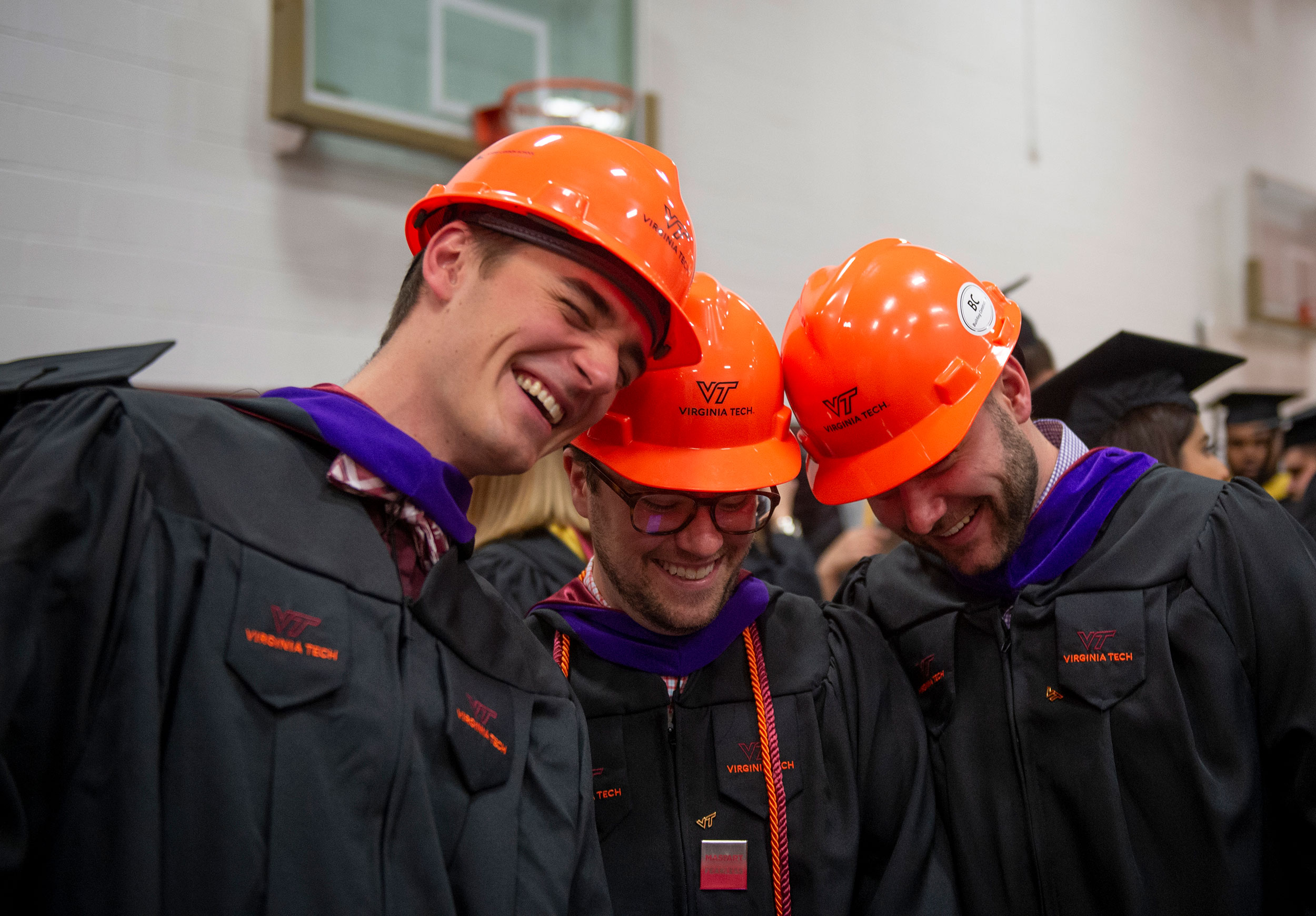 Graduates from the Myers-Lawson School of Construction don orange hard hats in lieu of the traditional cap.