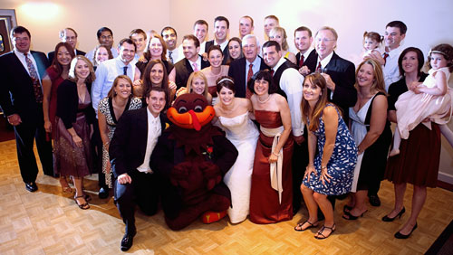 Ashley L. Smith '04 and Kristen Gates Smith '05 with the HokieBird and more than 30 Hokies